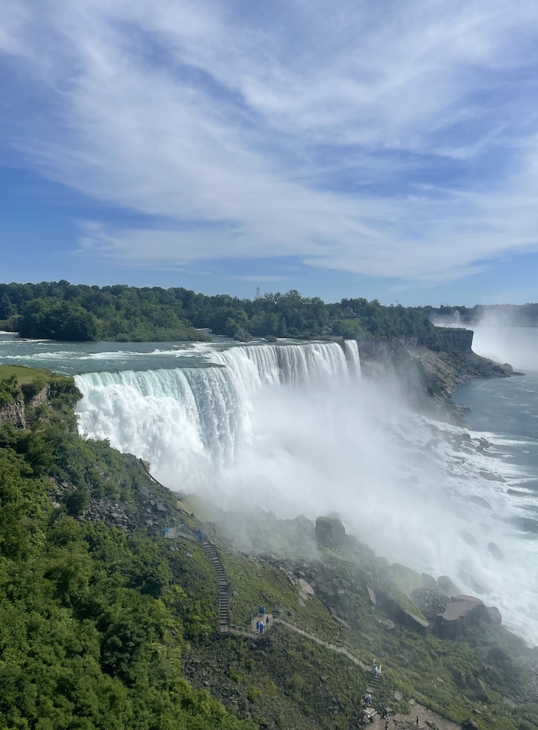 Massive, tall and wide waterfall with white foam surrounded by lush green hills. Niagara Falls State Park, United States View, Buffalo, Upstate, New York.