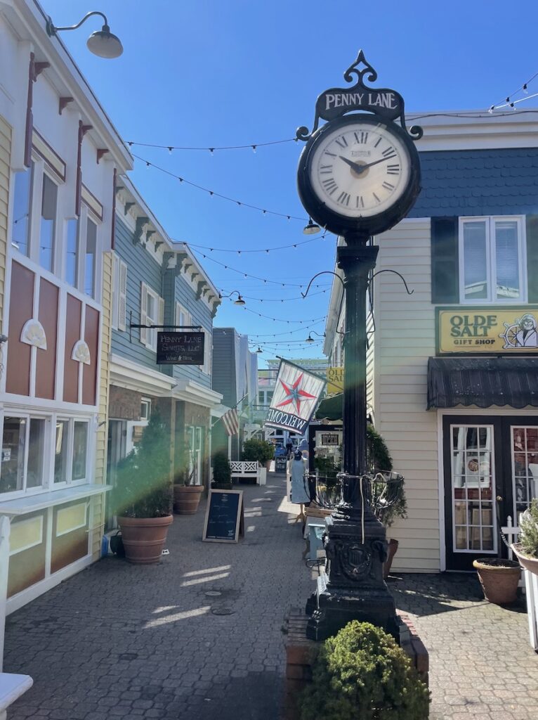 Boutique shopping area lined with colorful buildings, brick sidewalks, and antique clock. Rehoboth Avenue, Rehoboth Beach, Delaware.